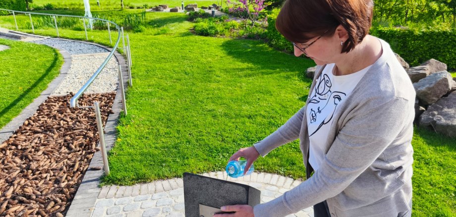 Drinking water fountain in the St. Jakob brine garden A woman draws water from a drinking fountain.