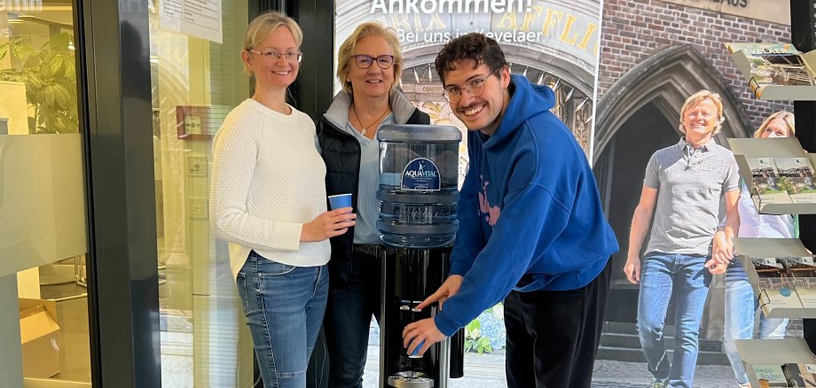 Employees of the pilgrimage town of Kevelaer stand in front of the drinking water dispenser