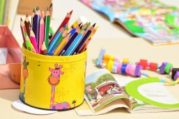 Box with colored pencils and notebooks
