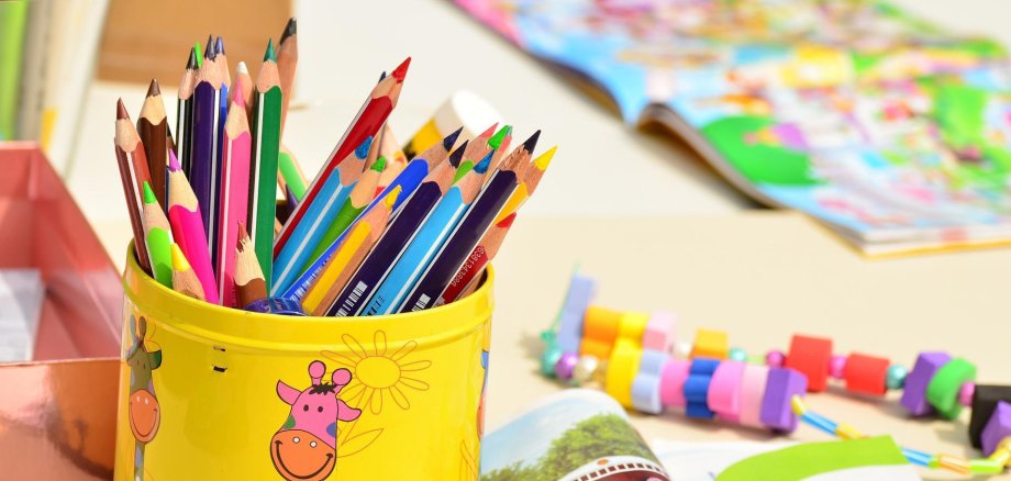 Box with colored pencils and notebooks