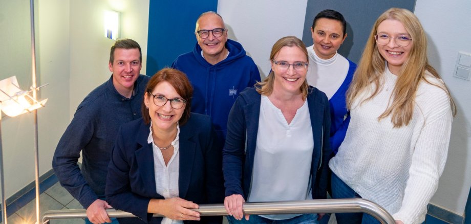 Contact bij NiersEnergie Vier vrouwen en twee mannen staan op een trap.