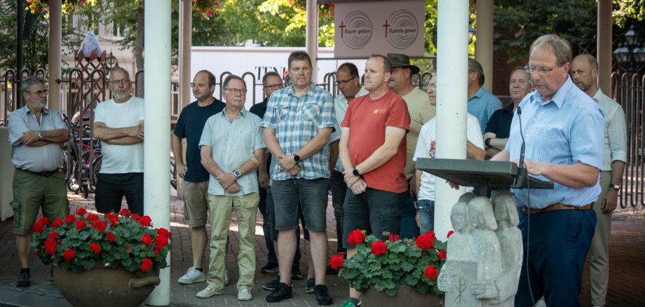 Energie voor Kevelaer" fonds Wolfgang Toonen staat achter de spreekstoel in het Forum Pax Christi. Achter hem hebben zich vertegenwoordigers van de schietverenigingen verzameld.