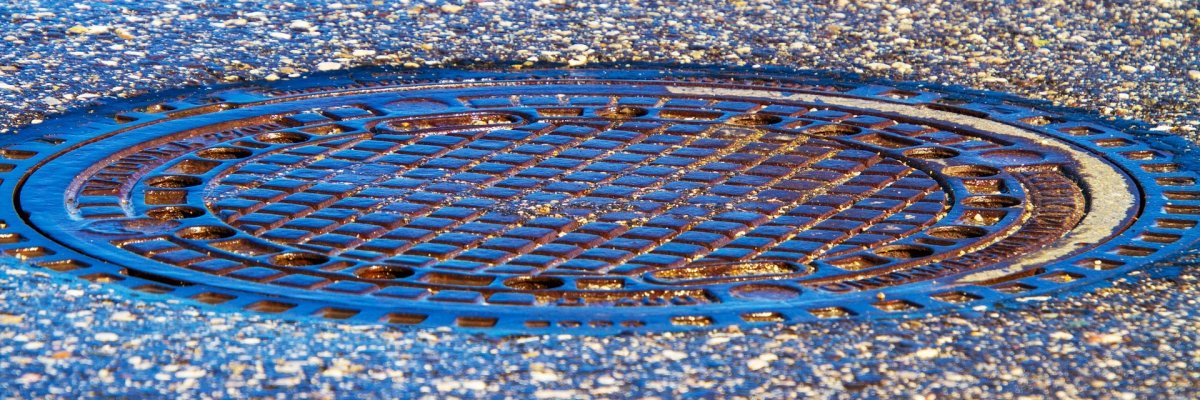 Een putdeksel in de straat