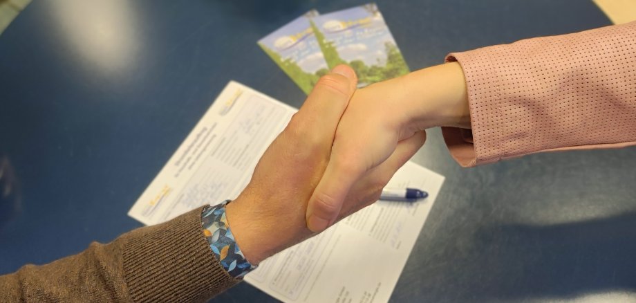 NiersEnergie elektriciteitsprijzen zullen dalen in 2025 Handen worden geschud over een formulier.