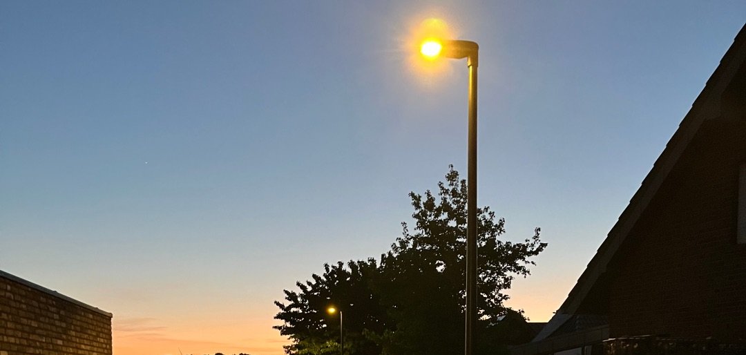 Leuchtende Straßenlaterne an einem Weg.