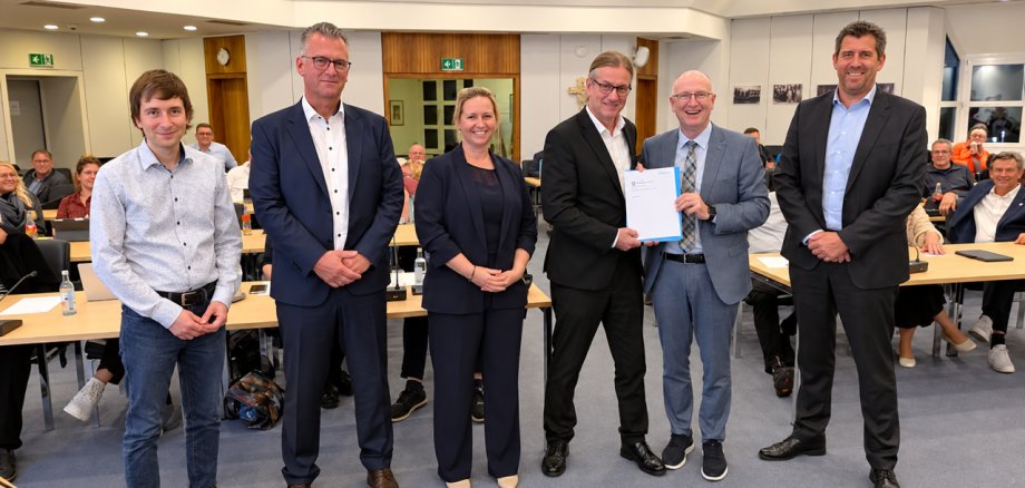 Der Präsident der GPA übergibt dem Bürgermeister einen Bericht. Daneben stehen drei Männer und eine Frau