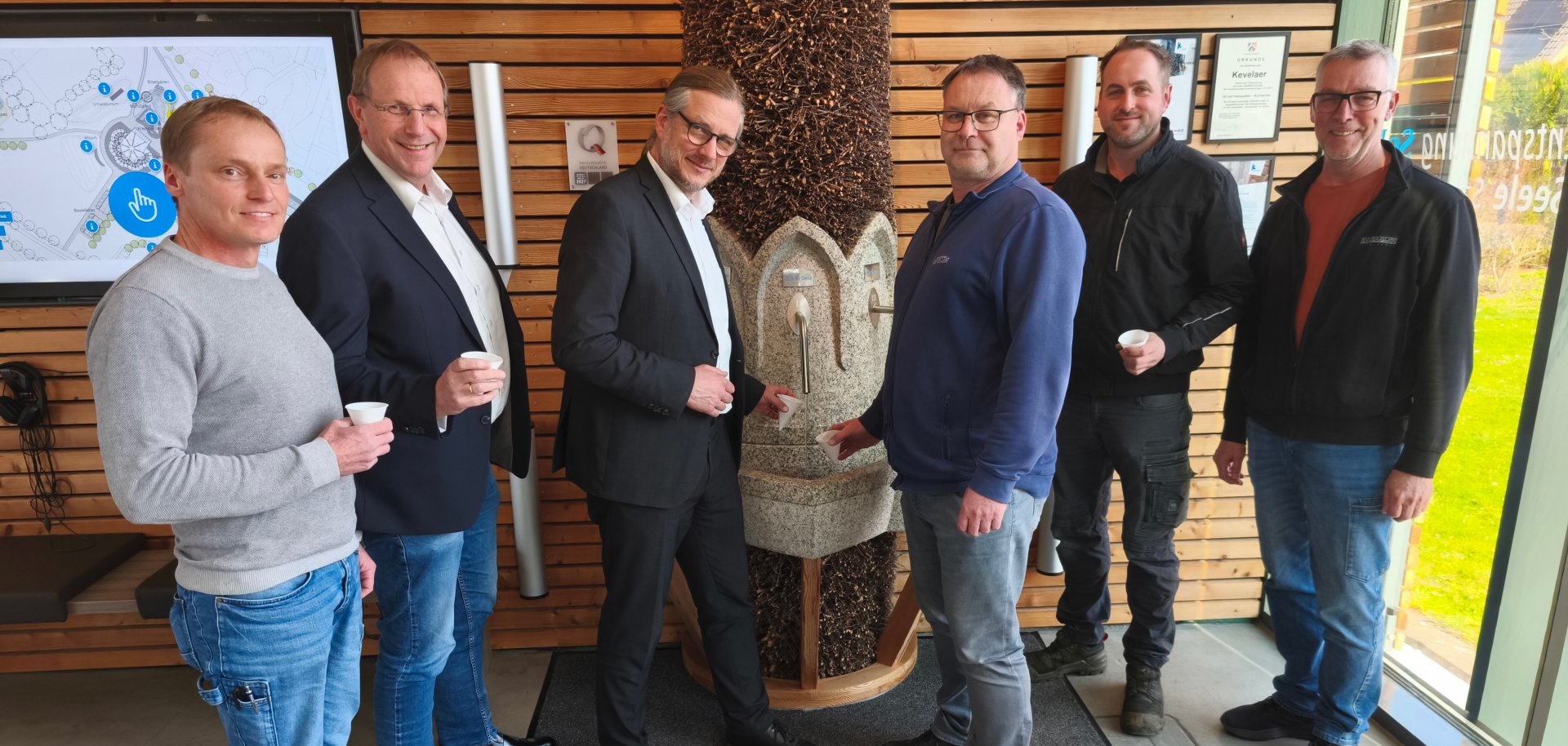 Mehrere Vertreter der Stadtwerke Kevelaer und der Wallfahrtsstadt Kevelaer stehen am neuen Trinkbrunnen im Solegarten St. Jakob.