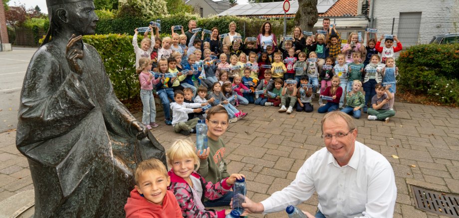 Erstklässler der St. Hubertus Grundschule mit neuen Trinkflaschen, gemeinsam mit Lehrkräften und Wolfgang Toonen.