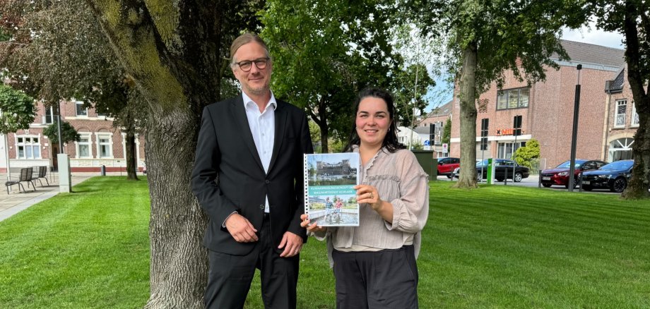 Bürgermeister und Klimaanpassungsmanagerin mit Klimaanpassungskonzept in der Hand